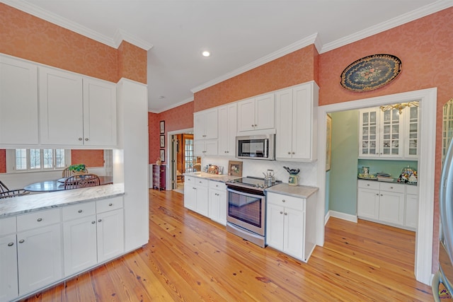 kitchen featuring appliances with stainless steel finishes, light hardwood / wood-style floors, and white cabinets