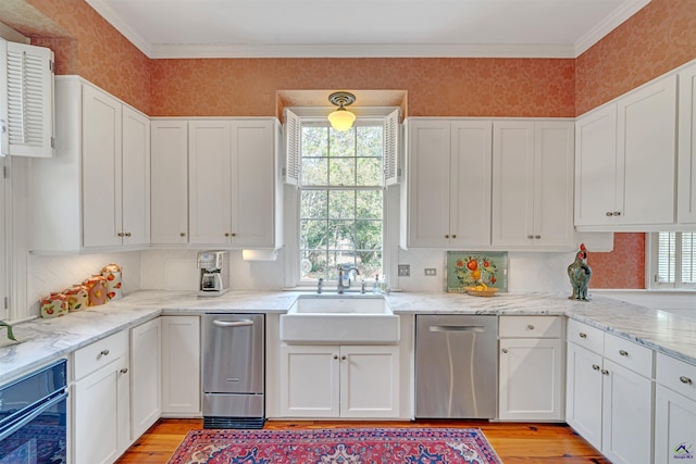 kitchen with white cabinetry, dishwasher, and sink