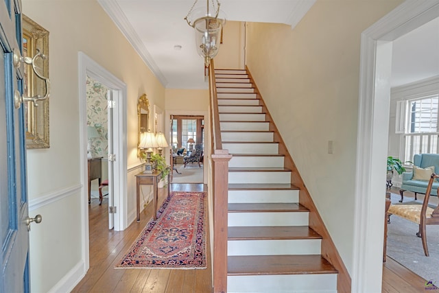 stairway featuring crown molding and hardwood / wood-style flooring