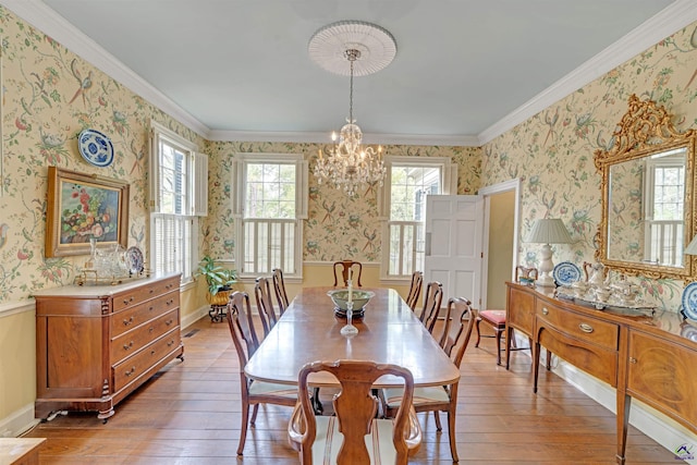 dining room with an inviting chandelier, ornamental molding, and hardwood / wood-style floors