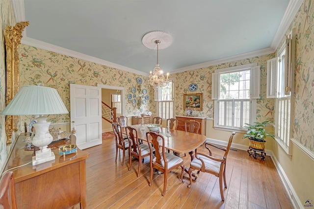 dining area featuring an inviting chandelier, hardwood / wood-style floors, and crown molding