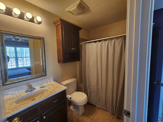 bathroom featuring tile patterned flooring, vanity, a textured ceiling, toilet, and walk in shower