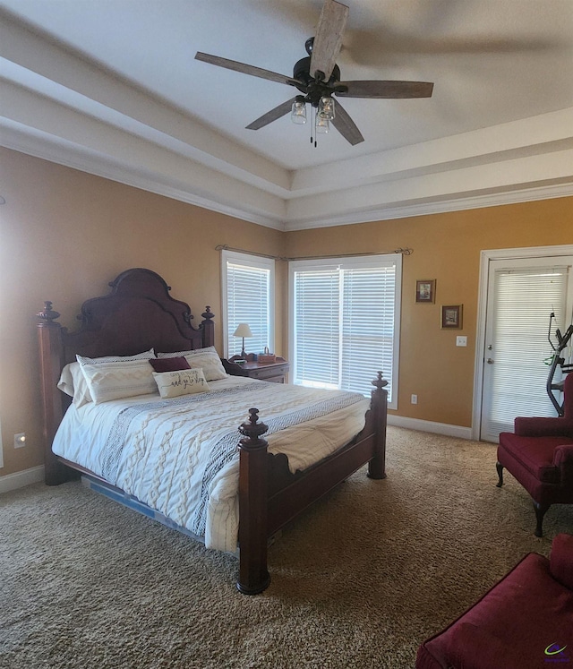 bedroom with ceiling fan, a tray ceiling, carpet flooring, and ornamental molding