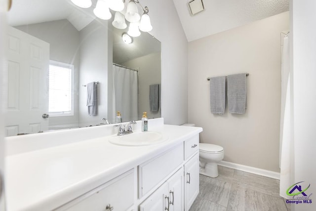 bathroom featuring lofted ceiling, vanity, a notable chandelier, and toilet