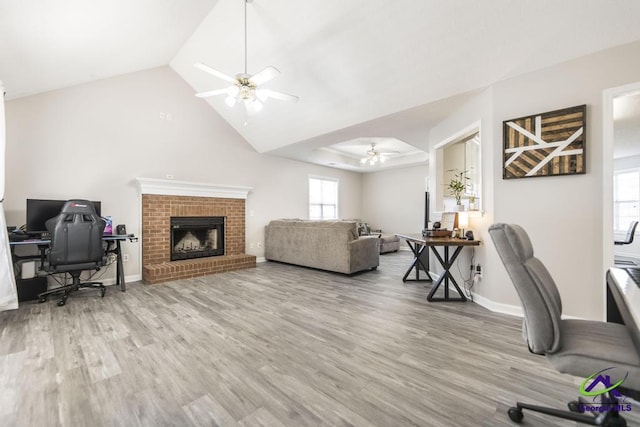 office with hardwood / wood-style flooring, vaulted ceiling, a fireplace, and ceiling fan