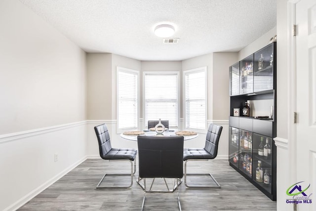 dining room featuring dark wood-type flooring and a textured ceiling