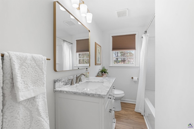 full bathroom with vanity, hardwood / wood-style floors, shower / tub combo, and toilet