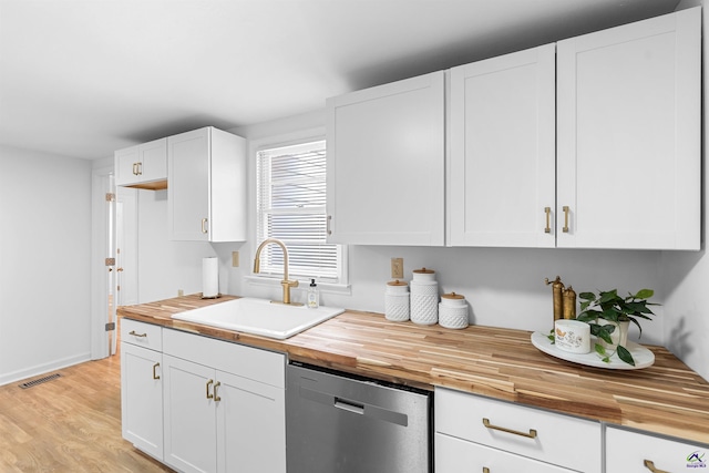 kitchen with white cabinetry, dishwasher, sink, and butcher block countertops