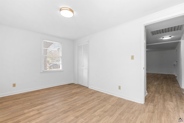 unfurnished bedroom with light hardwood / wood-style floors and a closet