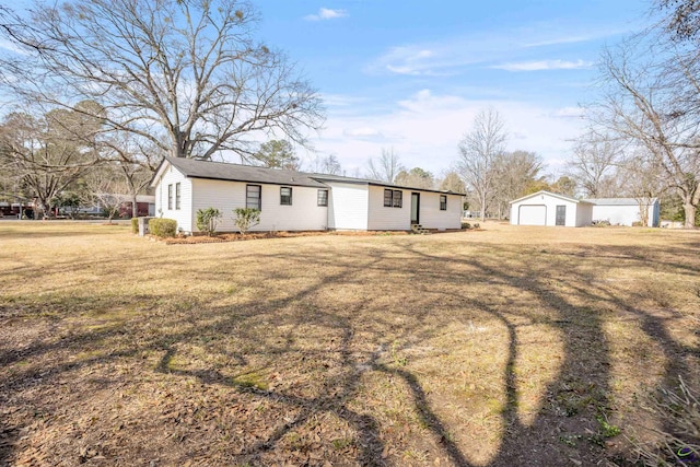 exterior space with a garage, an outbuilding, and a front yard