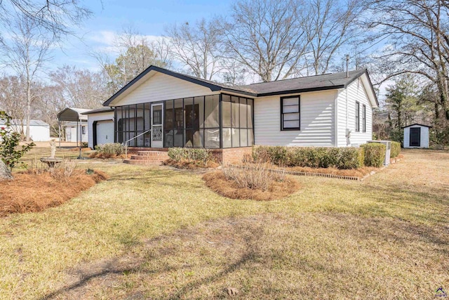 back of house featuring a garage, a yard, and a sunroom