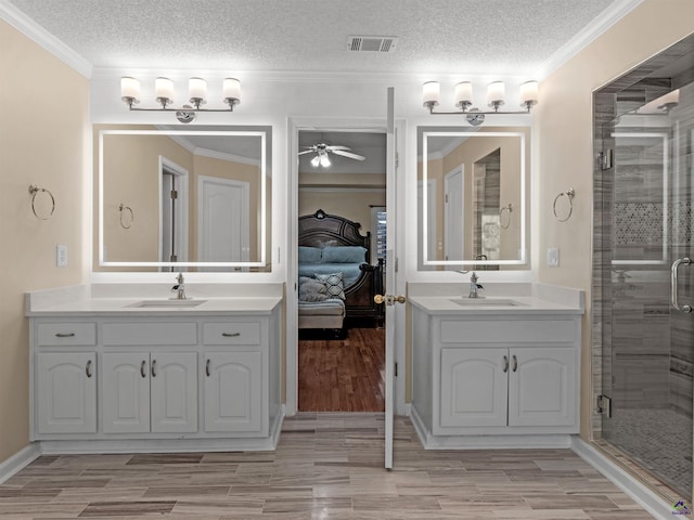 bathroom with hardwood / wood-style flooring, ornamental molding, vanity, and a textured ceiling