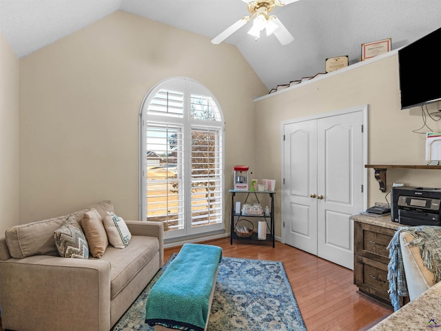 interior space with ceiling fan, vaulted ceiling, and light hardwood / wood-style flooring