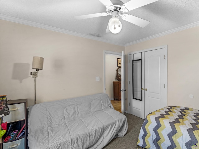 bedroom with crown molding, carpet, ceiling fan, and a closet