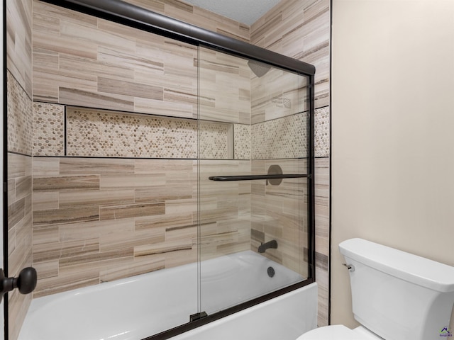 bathroom with bath / shower combo with glass door and toilet