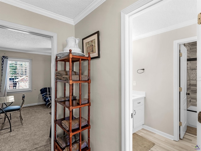 corridor featuring crown molding, a textured ceiling, and light hardwood / wood-style flooring