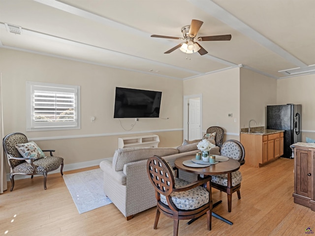 living room featuring sink, light hardwood / wood-style flooring, and ceiling fan