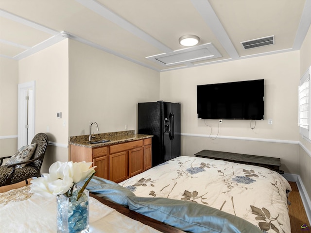 bedroom featuring sink and black fridge with ice dispenser