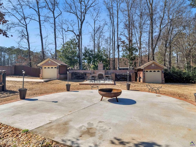 view of patio with a garage, an outbuilding, and an outdoor fire pit