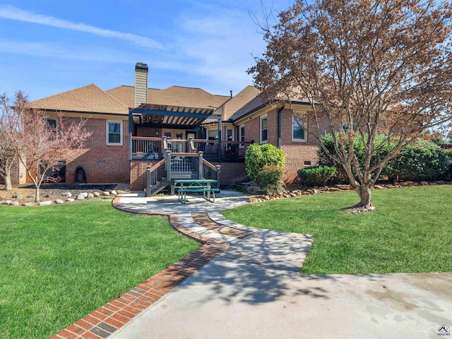 rear view of house featuring a wooden deck, a pergola, and a lawn