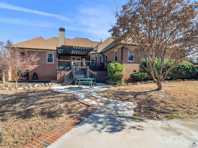 rear view of property featuring a wooden deck