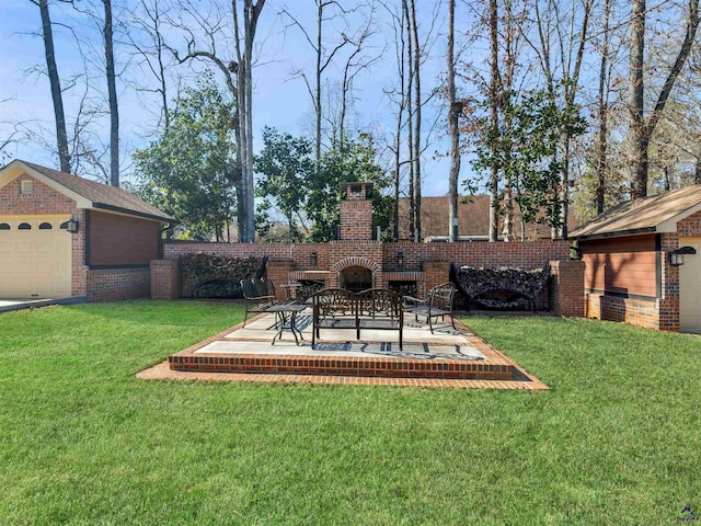 view of yard featuring an outdoor brick fireplace, a patio, a garage, and an outbuilding