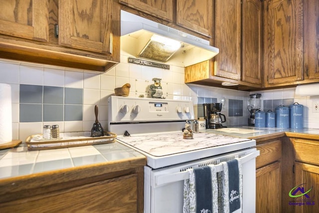 kitchen featuring tasteful backsplash, tile countertops, and white range with electric cooktop