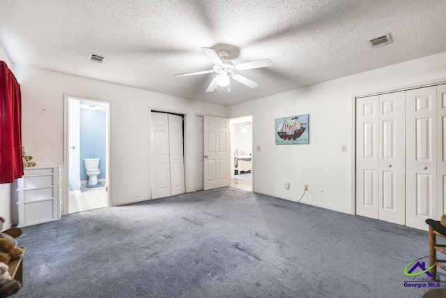 bedroom with connected bathroom, a textured ceiling, and carpet flooring