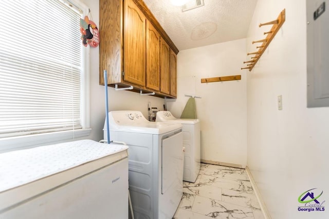 laundry area with washing machine and dryer, cabinets, and a textured ceiling