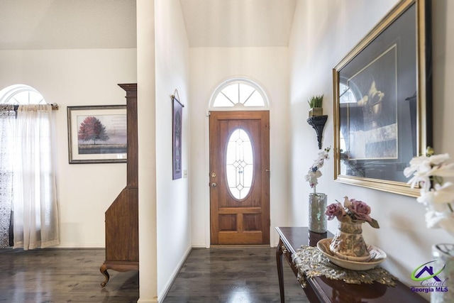 entryway with vaulted ceiling and dark hardwood / wood-style floors