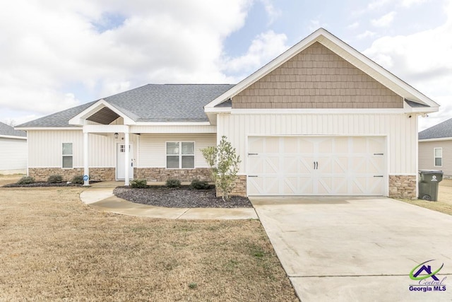 craftsman inspired home featuring a garage and a front lawn