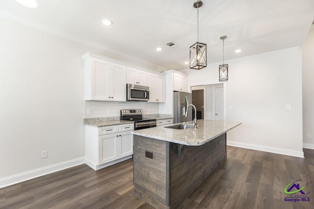 kitchen with sink, white cabinetry, hanging light fixtures, stainless steel appliances, and a kitchen island with sink