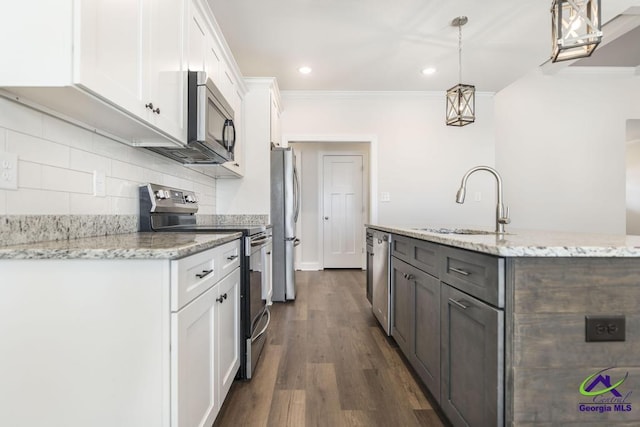 kitchen with sink, decorative light fixtures, appliances with stainless steel finishes, light stone countertops, and white cabinets