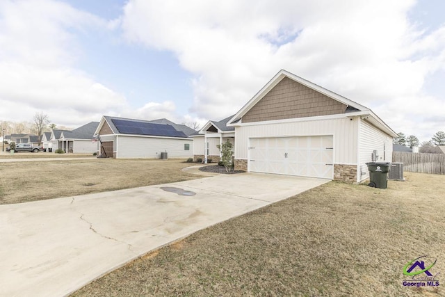 view of front of home featuring a garage, a front lawn, and central air condition unit