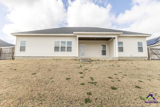 back of house with a lawn