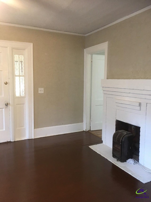 unfurnished living room with hardwood / wood-style flooring, ornamental molding, and a fireplace