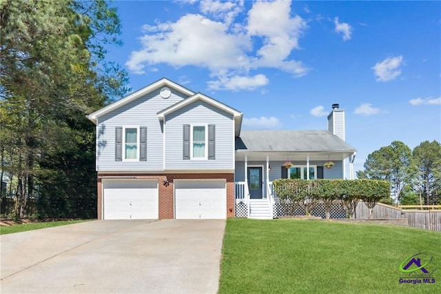 tri-level home featuring a garage, a front yard, and covered porch