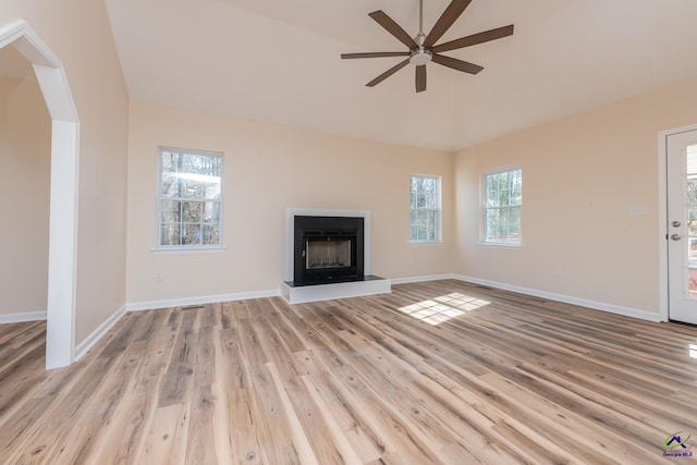 unfurnished living room featuring ceiling fan, a wealth of natural light, and light wood-type flooring