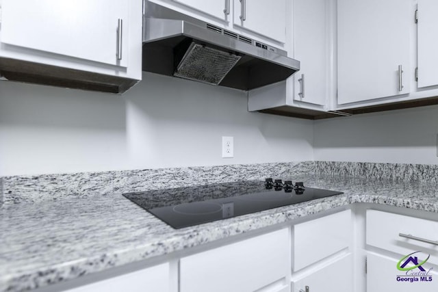 kitchen with white cabinetry, black electric stovetop, and light stone counters