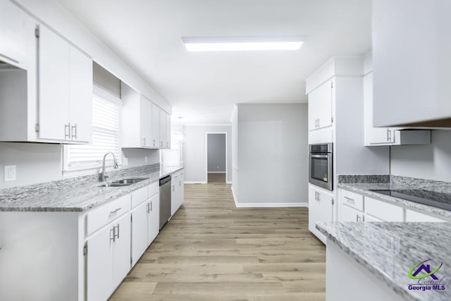 kitchen featuring white cabinetry, sink, stainless steel appliances, and light wood-type flooring