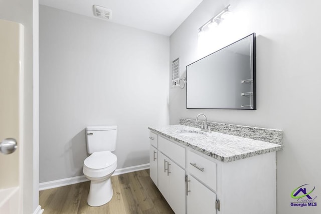 bathroom featuring vanity, hardwood / wood-style flooring, and toilet