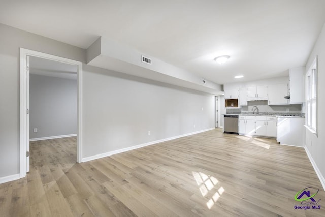 unfurnished living room featuring sink and light hardwood / wood-style flooring