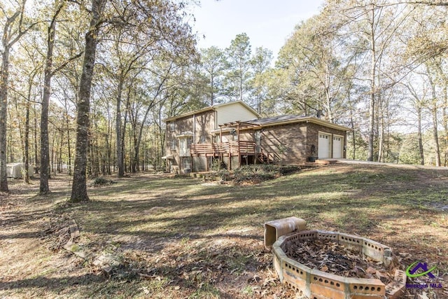 exterior space featuring a wooden deck and a fire pit