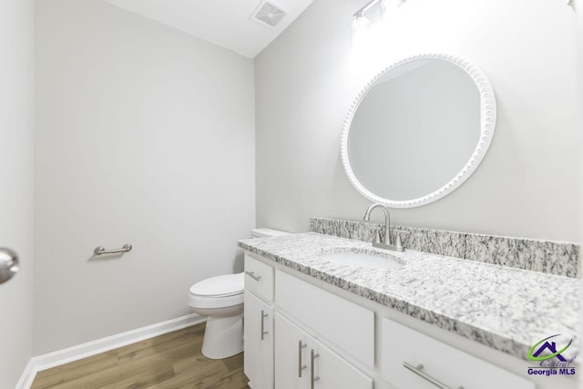 bathroom featuring vanity, toilet, and hardwood / wood-style floors