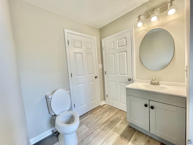 bathroom featuring vanity, hardwood / wood-style flooring, and toilet