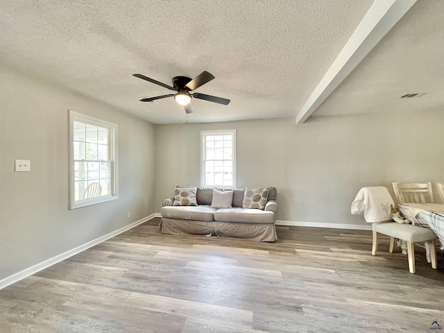 unfurnished room with a textured ceiling, ceiling fan, and light wood-type flooring