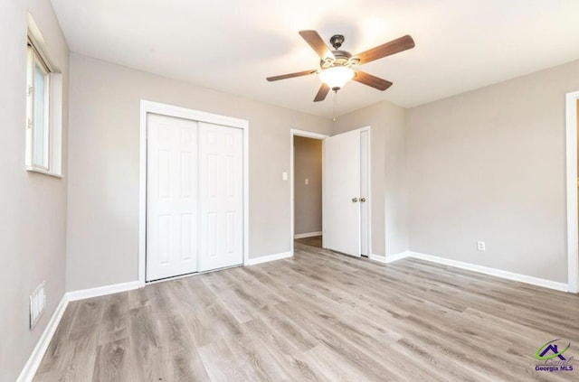 unfurnished bedroom with ceiling fan, light wood-type flooring, and a closet