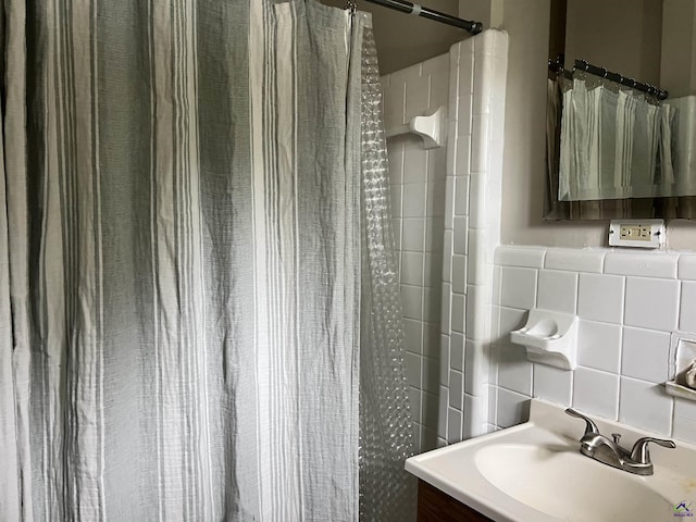 bathroom featuring tile walls, vanity, and walk in shower