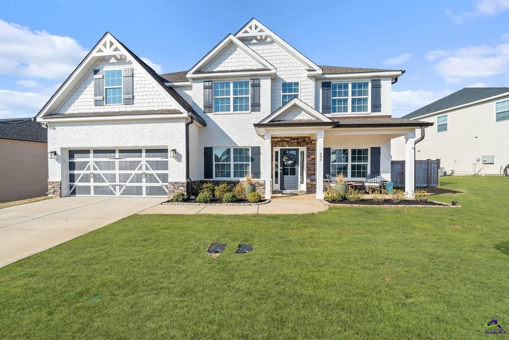 406 Shoshone Cir, Kathleen, GA 31047 - craftsman-style house with a garage, a front lawn, and covered porch
