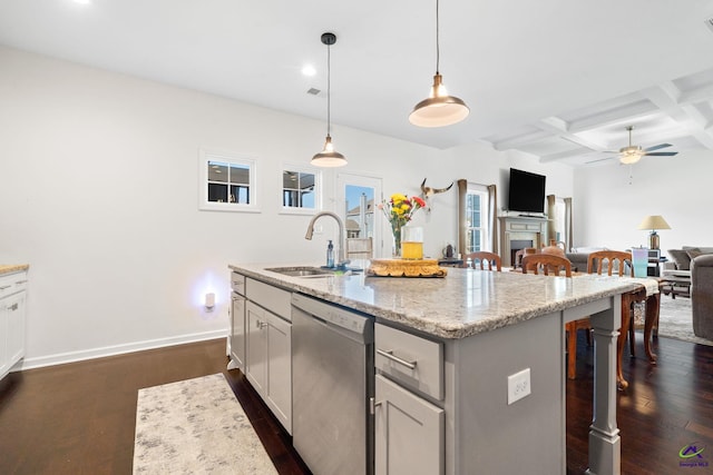 kitchen featuring pendant lighting, sink, a breakfast bar area, a center island with sink, and stainless steel dishwasher